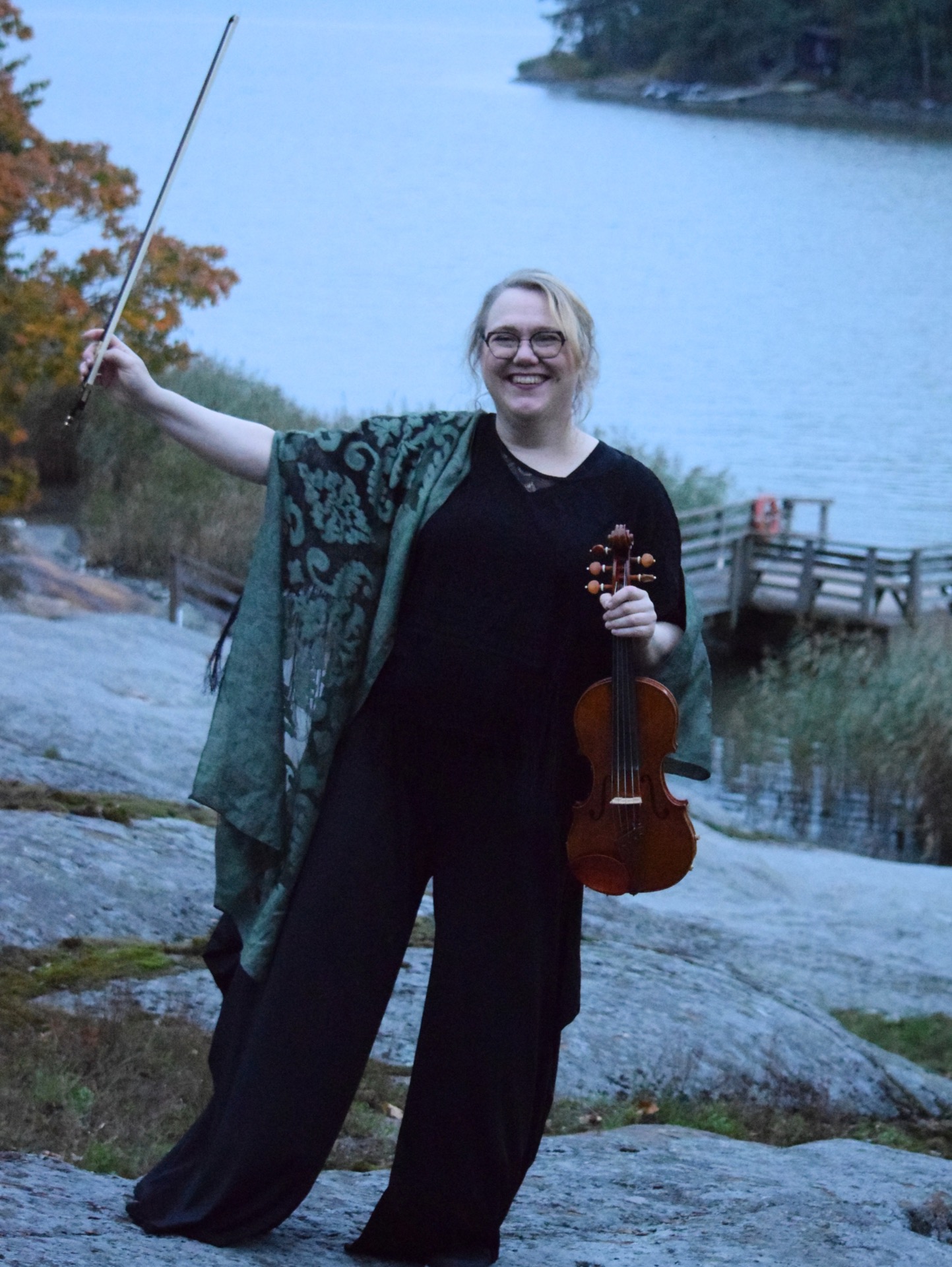 Katriina Rainio, viulisti ja musiikkipedagogi, viulu kädessä rantakallioilla